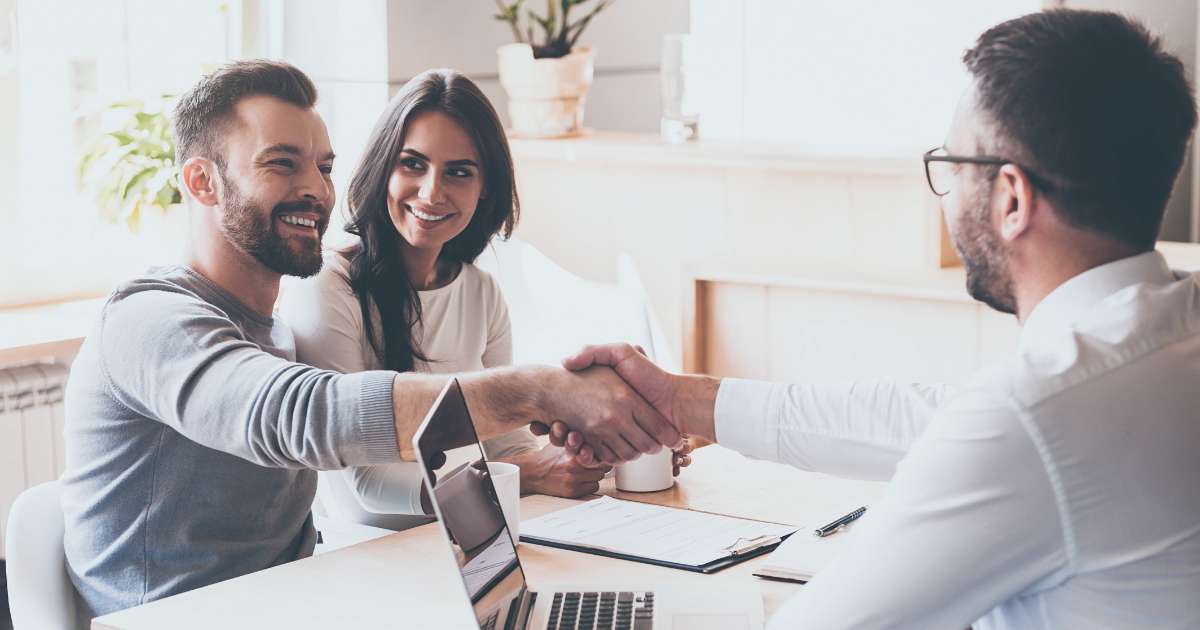 couple shakes hand with realtor