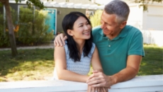 couple in yard talking next to fence