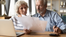 couple looking at documents and computer data to figure out home worth