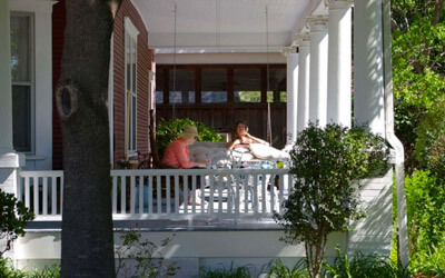 two people sitting on the porch of a house