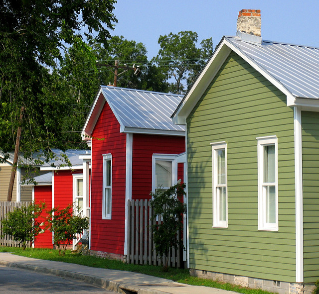 Three houses in a row in a neighborhood street.