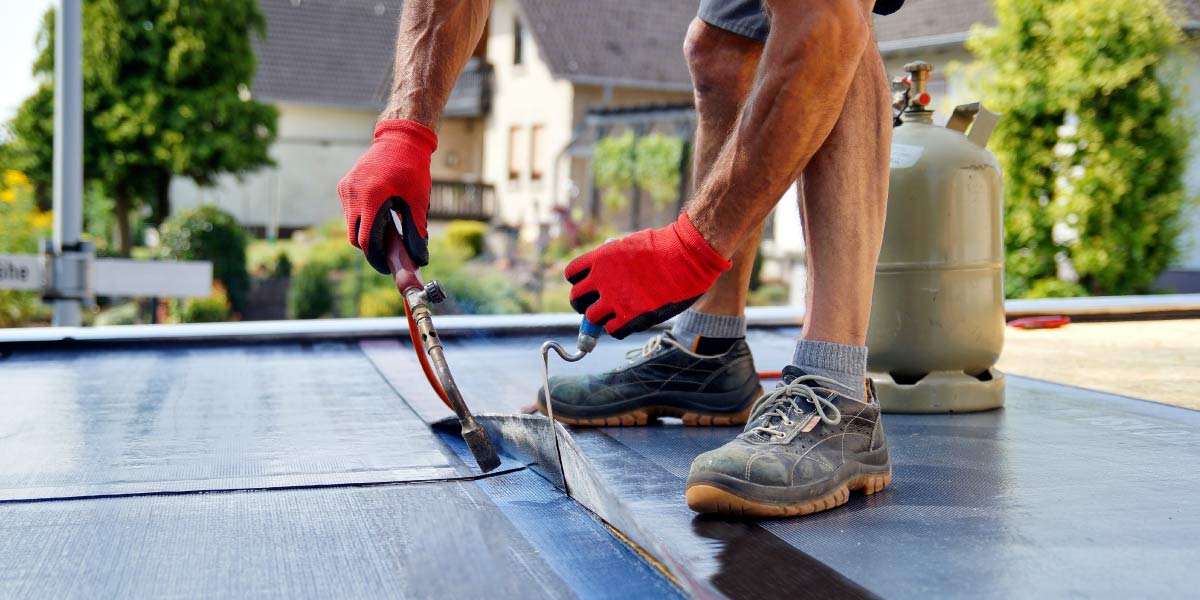 man repairing flat roof