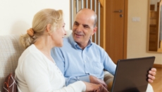 couple talking next to computer while researching how to sell house